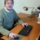 Steve Gibson sits at a desk that was once covered with mustard paraphernalia.